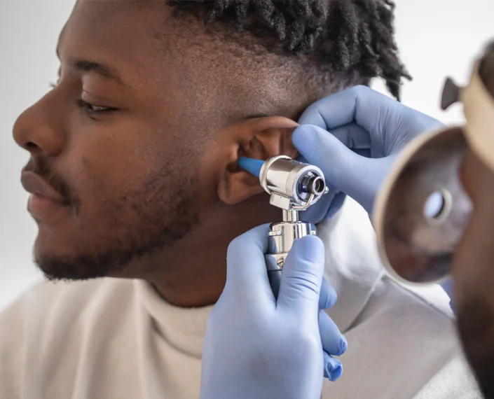Man having ears checked with an otoscope